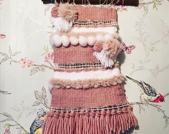 Handgemaakte roze geweven muurhanger met pompons en franje