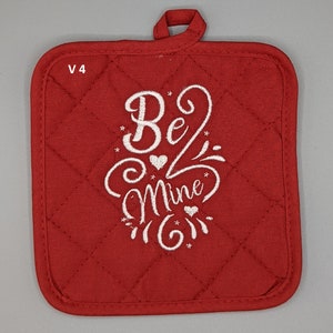 May include: Red quilted pot holder with a white embroidered design that says "Be Mine" with hearts and stars.