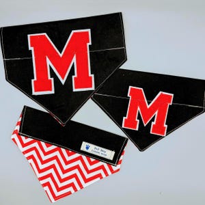 May include: Three black dog bandanas with red felt letter M. One bandana has a red and white chevron pattern on the reverse side. The bandana has a label that reads "Pup Pets Exclusive Design".