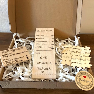 Può includere: Una confezione regalo con targhe in legno e un adesivo di ringraziamento. Le targhe recitano "Official Teacher Access" e "One Amazing Teacher". La scatola contiene carta sminuzzata. L'adesivo dice "Hand Made With Love."