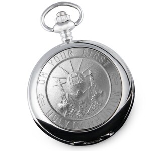 May include: Silver pocket watch with a design of a chalice and host with the words "On Your First Holy Communion" around the edge.