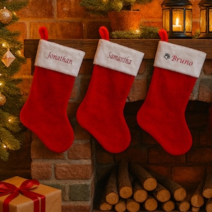 May include: Three red Christmas stockings with white cuffs hang above a fireplace. Each stocking has a name embroidered in red: "Jonathan", "Samantha", and "Bruno". A paw print is next to the name "Bruno".