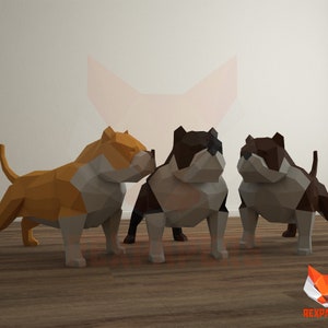 Puede incluir: Tres modelos de perros American Bully de papel origami. Los perros están de pie sobre un suelo de madera. Los perros son marrones, negros y naranjas.