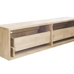 K&ouml;nnte beinhalten: Eine wandmontierte Medienkonsole aus hellem Holz mit zwei offenen Schubladen. Die Schubladen sind offen und leer.