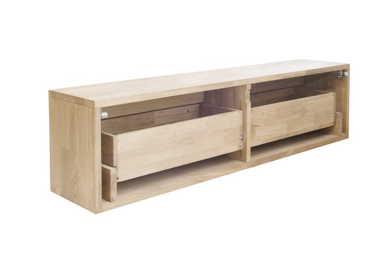 K&ouml;nnte beinhalten: Eine wandmontierte Medienkonsole aus hellem Holz mit zwei offenen Schubladen. Die Schubladen sind offen und leer.