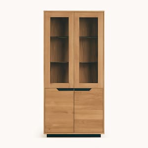 Op de afbeelding: Een hoge houten kast met glazen deuren en twee lagere houten deuren. De kast heeft een donkerhouten frame en zwarte beslag.