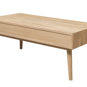 Puede incluir: Una mesa de centro de madera clara con un caj&oacute;n y patas c&oacute;nicas. La mesa est&aacute; hecha de madera maciza y tiene un acabado natural.