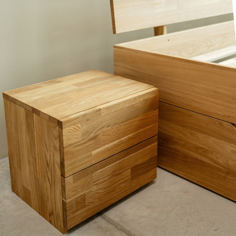 May include: A wooden nightstand with two drawers. The nightstand is made of light brown wood and has a simple, modern design.