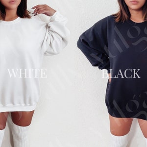 May include: Two oversized sweatshirts, one white and one black, with a crew neck and long sleeves. The sweatshirts are shown on models wearing white knee-high socks.