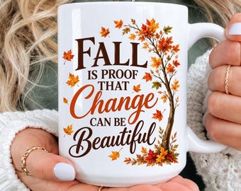 May include: A white ceramic mug featuring a graphic of a tree with autumn leaves in shades of orange, red, and yellow. The text printed on the mug reads, "FALL IS PROOF THAT Change CAN BE Beautiful" in a combination of serif and script fonts.