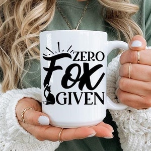 May include: White ceramic mug with black text that reads "Zero Fox Given".