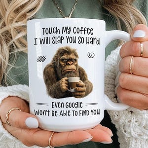 May include: White ceramic coffee mug with the text "Touch My Coffee I Will SLAP You So Hard" and "Even Google Won't Be Able To FIND YOU". The mug features a brown illustration of a gorilla holding a coffee cup. A humorous gift.
