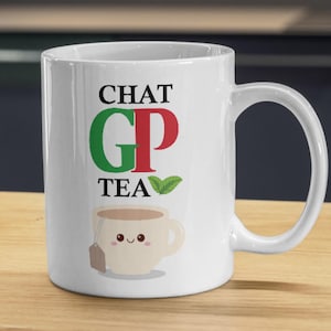 May include: A white ceramic mug featuring the black text CHAT and TEA, with a large green G and red P in the centre. Below the text is a small illustration of a smiling beige teacup with a tea bag and a green leaf graphic next to the word TEA.