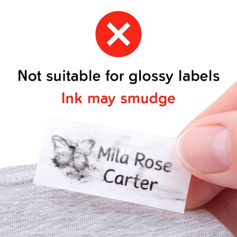 May include: A white label with the name "Mila Rose Carter" and a butterfly graphic, with smudged ink. The text "Not suitable for glossy labels" and "Ink may smudge" is displayed above the label, with a red "X" symbol.