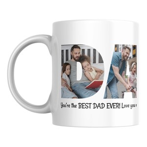 Puede incluir: Taza de cer&aacute;mica blanca con un asa grande. La taza presenta la palabra "DAD" en una fuente estilizada, con fotos familiares integradas en las letras. El texto "You're the BEST DAD EVER! Love you" est&aacute; impreso debajo.