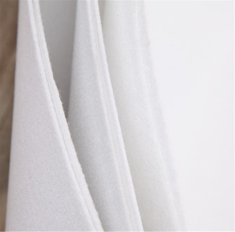 May include: Close-up of three white fabric swatches, showing the texture and weave of the material.