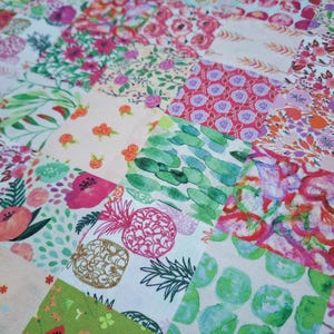 Peut inclure: Un tissu patchwork avec une variété de motifs floraux et géométriques dans des tons de rose, vert et blanc.