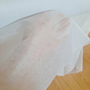 May include: White non-woven fabric, often used for crafts, packaging, or as a protective layer.