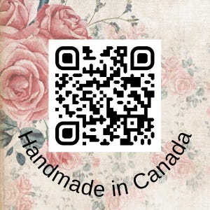 May include: A square black and white QR code centered on a background featuring a vintage-style pattern of soft pink roses and green leaves. The text "Handmade in Canada" is printed in black, sans-serif font along the bottom edge.