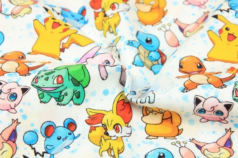 May include: White fabric with a repeating pattern of colourful cartoon characters, including Pikachu, Bulbasaur, and Squirtle. The design includes blue polka dots, creating a playful and vibrant aesthetic. Suitable for crafting or clothing.