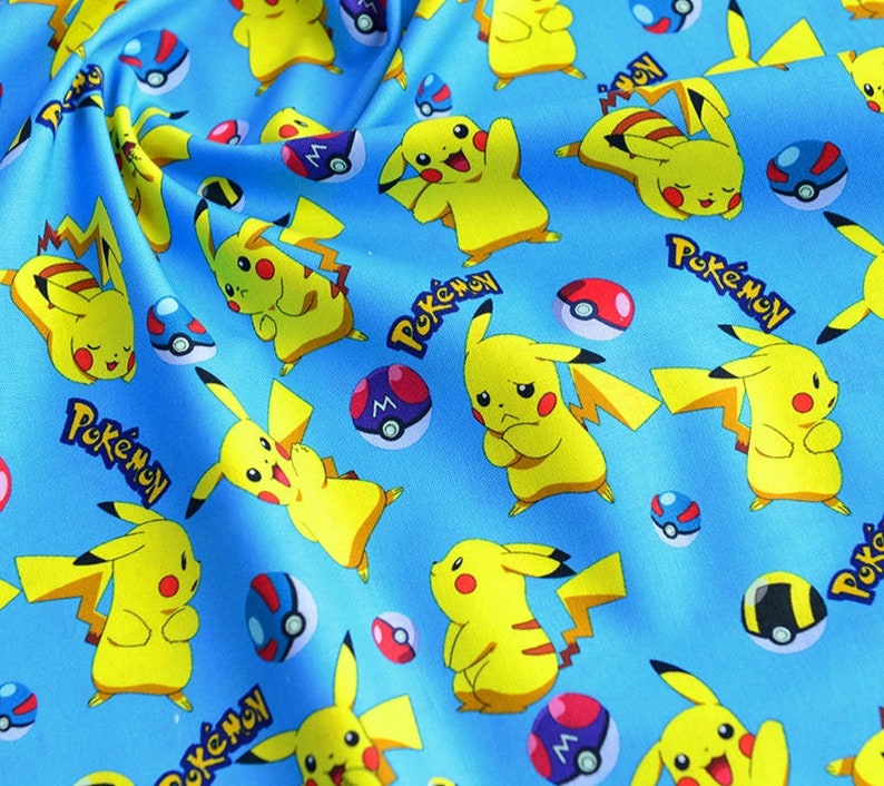 May include: Light blue fabric with a repeating pattern of yellow Pikachu characters, red and white Pok&eacute; Balls, and the word "Pok&eacute;mon" in white. Ideal for crafting projects, the fabric has a playful design.