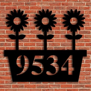 May include: Black metal house number sign with three sunflowers in a planter. The numbers 9534 are cut out of the planter.