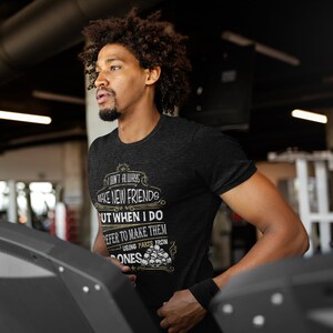 May include: A black t-shirt with a white graphic print that says "I don't always make new friends but when I do I prefer to make them using parts from bones". The graphic is surrounded by a decorative border and includes a skull and crossbones design.