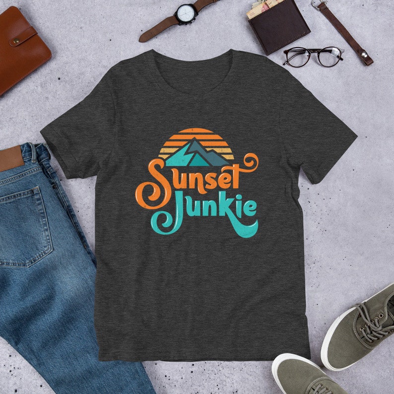 May include: A dark heather grey t-shirt with a sunset graphic and the text "Sunset Junkie" in a retro font.