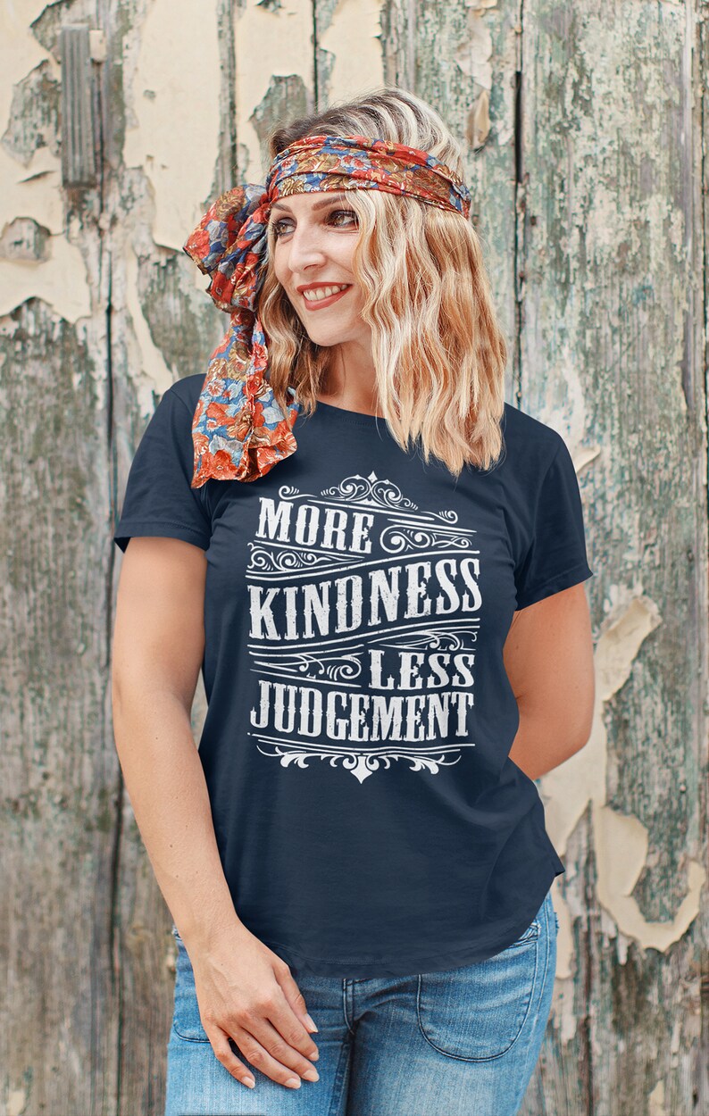 May include: A navy blue t-shirt with a white vintage-style graphic that reads "More Kindness Less Judgement".