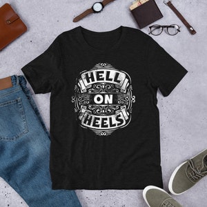 May include: Black t-shirt with a white vintage-style graphic that says "Hell On Wheels".