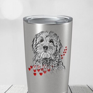 May include: A silver insulated travel mug with a grayscale illustration of a fluffy dog and red heart accents. The dog portrait is surrounded by small red hearts. The travel mug has a silver lid, perfect for hot or cold beverages.
