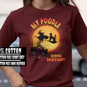 May include: A maroon t-shirt with a graphic of a witch riding a broomstick with a poodle. The text "My Poodle Rides Shotgun" is printed on the shirt.