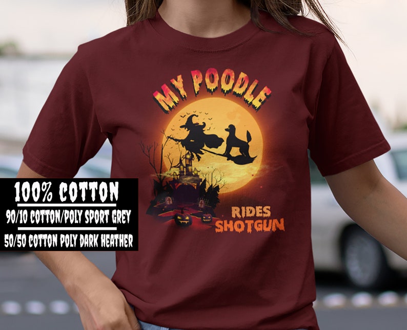 May include: A maroon t-shirt with a graphic of a witch riding a broomstick with a poodle. The text "My Poodle Rides Shotgun" is printed on the shirt.