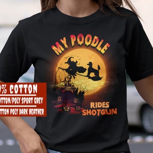 May include: Black t-shirt with a graphic of a poodle riding a broomstick with a witch. The text "My Poodle Rides Shotgun" is printed on the shirt.