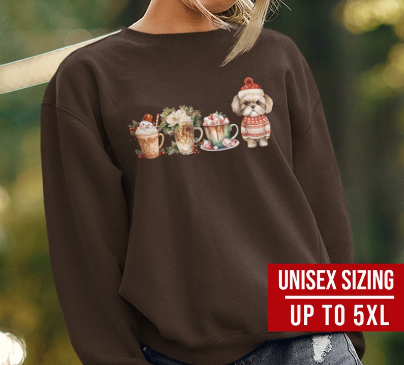 May include: A brown sweatshirt with a graphic of a dog wearing a Santa hat and holding a cup of hot chocolate. The graphic also includes other cups of hot chocolate and a snowman. The sweatshirt has the text "Unisex Sizing Up to 5XL" printed on the bottom right corner.