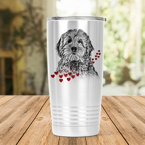 May include: A white insulated travel mug with a black and white dog illustration and red heart accents. The mug has a silver lid and a ridged design near the base. The dog illustration is detailed and centered on the mug. The mug is designed to keep drinks hot or cold.
