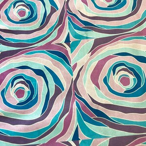 Puede incluir: Un patr&oacute;n de tejido sin costuras con un dise&ntilde;o repetitivo de c&iacute;rculos conc&eacute;ntricos en tonos de azul, morado y rosa.