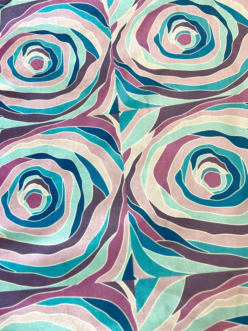 Puede incluir: Un patr&oacute;n de tejido sin costuras con un dise&ntilde;o repetitivo de c&iacute;rculos conc&eacute;ntricos en tonos de azul, morado y rosa.