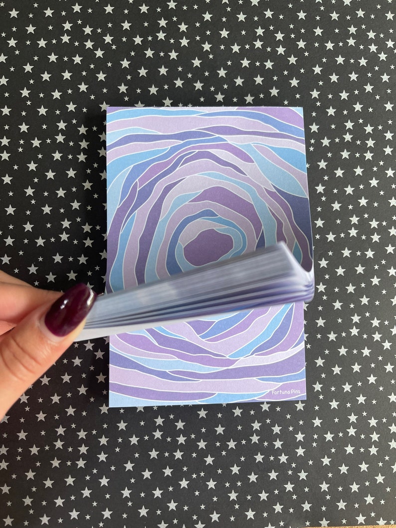 May include: A stack of purple and blue patterned memo pads with the text "Fortuna Pics" on the bottom right corner.