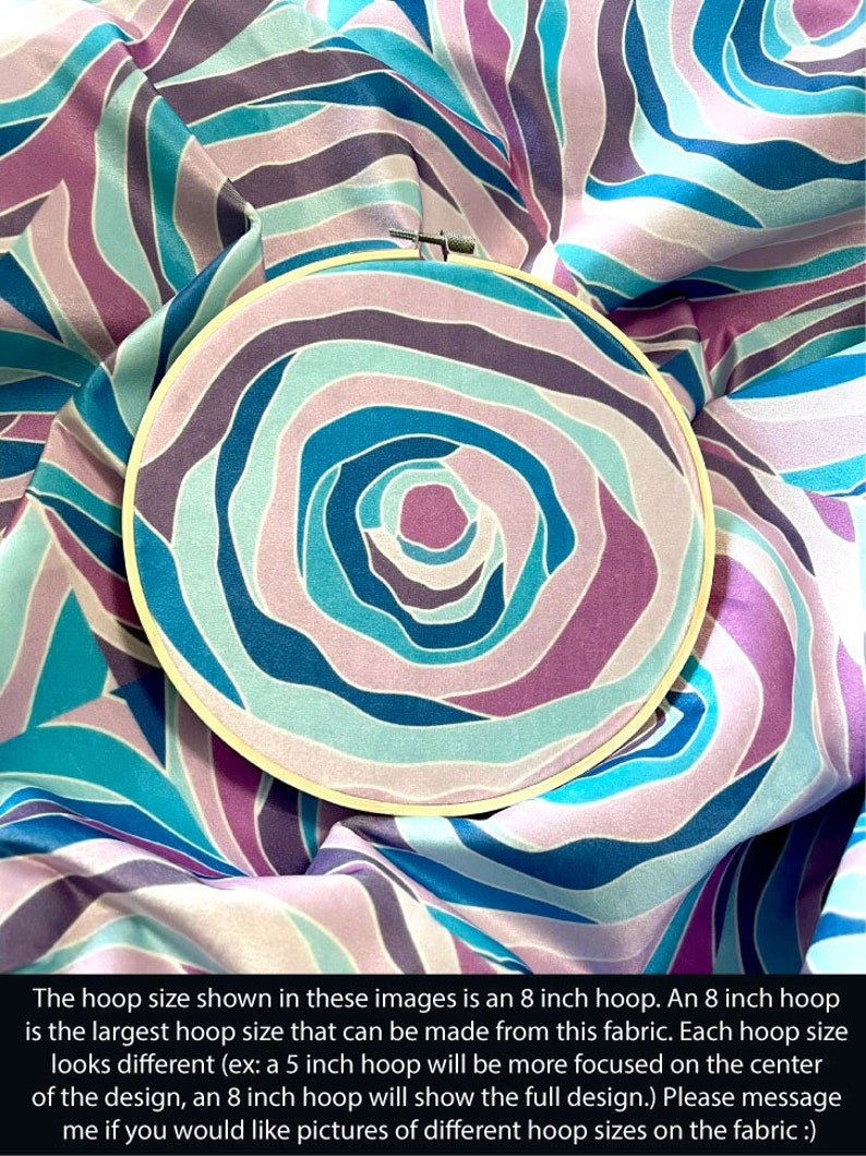Puede incluir: Primer plano de una tela con un patr&oacute;n de remolino en tonos de azul, morado y rosa. La tela est&aacute; estirada sobre un aro de bordado de 20 cm. El tama&ntilde;o del aro que se muestra en estas im&aacute;genes es un aro de 20 cm. Un aro de 20 cm es el tama&ntilde;o de aro m&aacute;s grande que se puede hacer con esta tela. Cada tama&ntilde;o de aro tiene un aspecto diferente (por ejemplo: un aro de 12,5 cm estar&aacute; m&aacute;s centrado en el centro del dise&ntilde;o, un aro de 20 cm mostrar&aacute; el dise&ntilde;o completo). Por favor, env&iacute;ame un mensaje si quieres fotos de diferentes tama&ntilde;os de aro en la tela :)