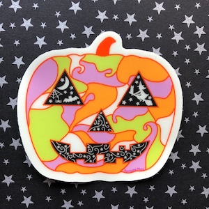 May include: A sticker of a jack-o'-lantern with a psychedelic design. The pumpkin is orange, yellow, green, and purple. The eyes and mouth are black with a white swirl pattern. The sticker has the text "Fortune Pins" at the bottom.