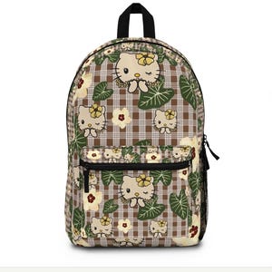 May include: A backpack featuring a brown and white plaid pattern with a repeating print of Hello Kitty characters wearing yellow flowers, interspersed with green tropical leaves and cream-colored hibiscus flowers, including a front zippered pocket.