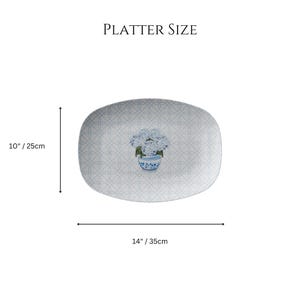 May include: A white oval platter with a blue and white floral design. The platter measures 10 inches by 14 inches.