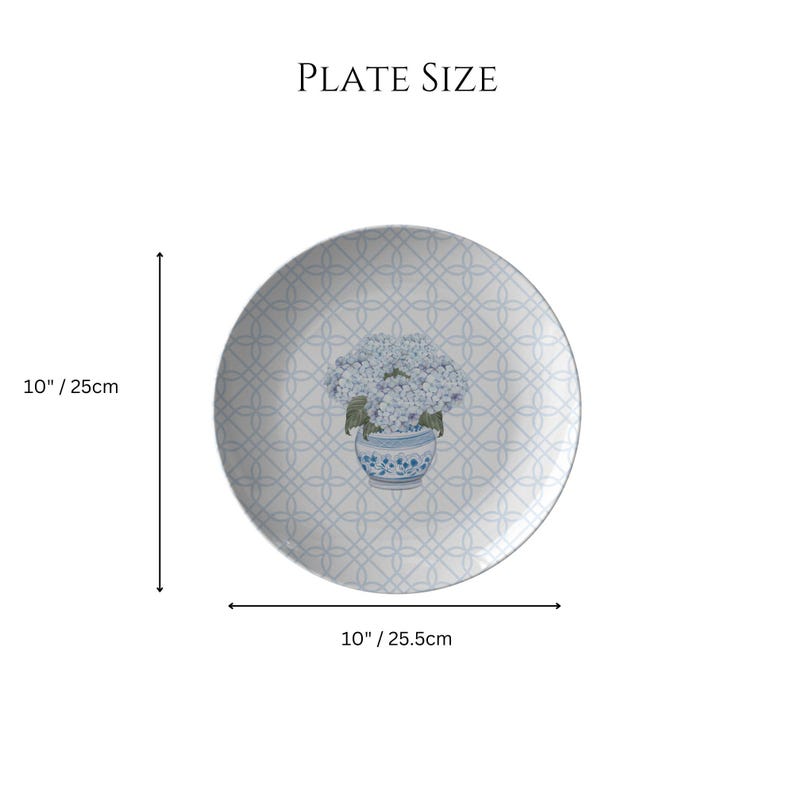 May include: A 10-inch white ceramic plate with a blue and white floral design. The plate features a repeating pattern of blue circles and a floral motif in the center. The floral motif is a bouquet of blue hydrangeas in a blue and white vase.