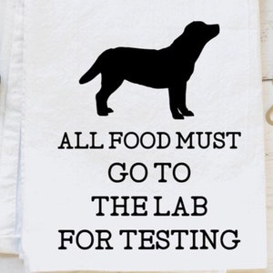 May include: A black and white kitchen towel with a silhouette of a Labrador Retriever and the text "All food must go to the lab for testing."