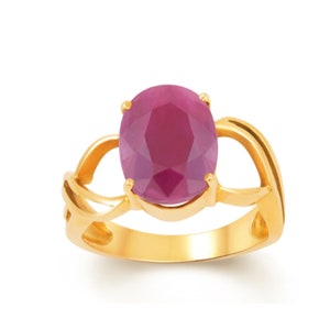 Peut inclure: Une bague en or ornée d'un grand rubis de forme ovale. Le rubis est d'un rouge profond. La monture de la bague présente un design ajouré. La bague est posée sur un fond blanc. Le design est élégant.