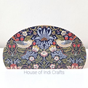 Könnte beinhalten: Eine halbkreisförmige Holzplatte mit dunkelblauem Hintergrund und einem sich wiederholenden Muster aus Vögeln, Erdbeeren und Blumenmotiven in Grün-, Rosa- und Weißtönen. Der Text House of Indi Crafts ist unten mittig aufgedruckt.