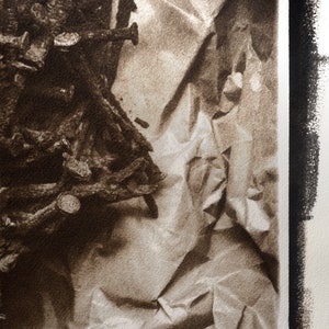 May include: A close-up of a pile of rusty metal nails and screws on a crumpled brown paper background.