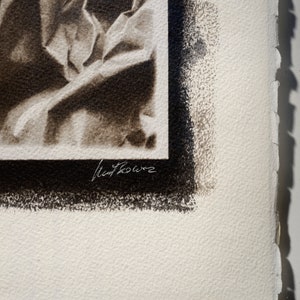 May include: A black and white photograph of a draped fabric with a black border and the artist's signature "Matt Rowe" in the bottom right corner.
