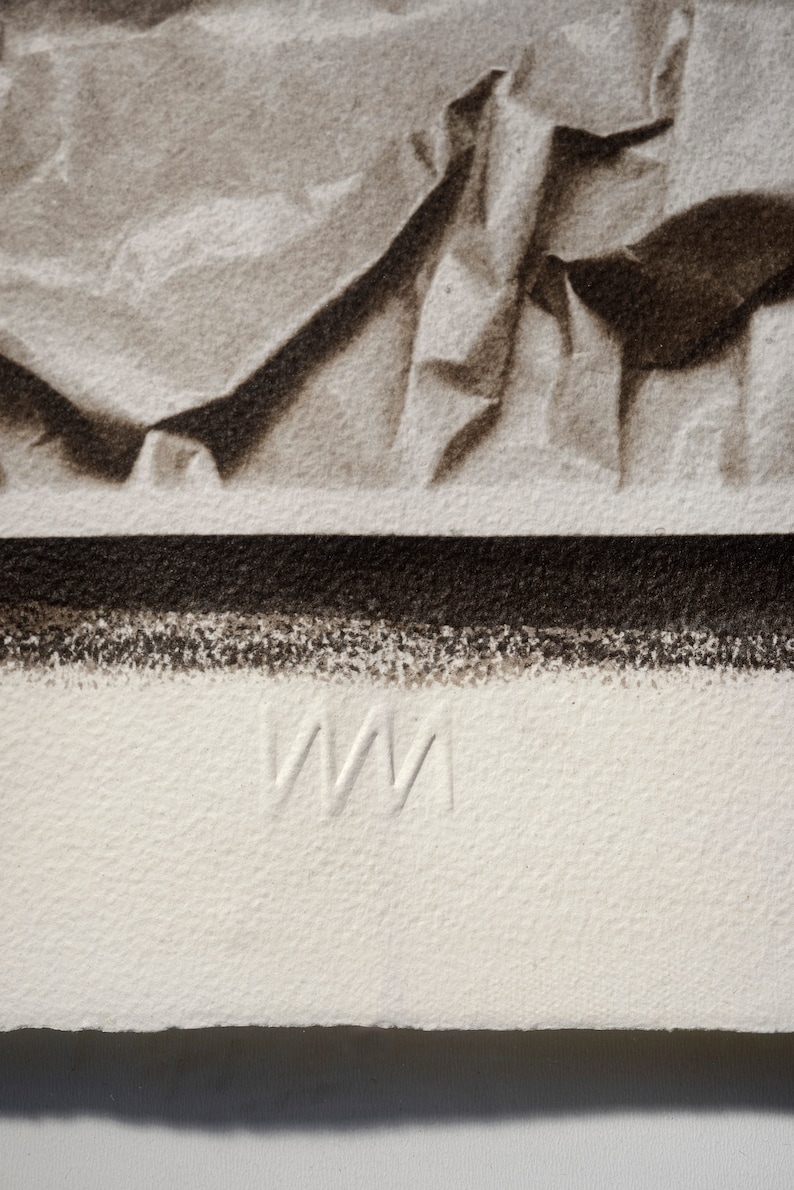 May include: A close-up of a white, textured surface with the letters "WM" embossed in the center.